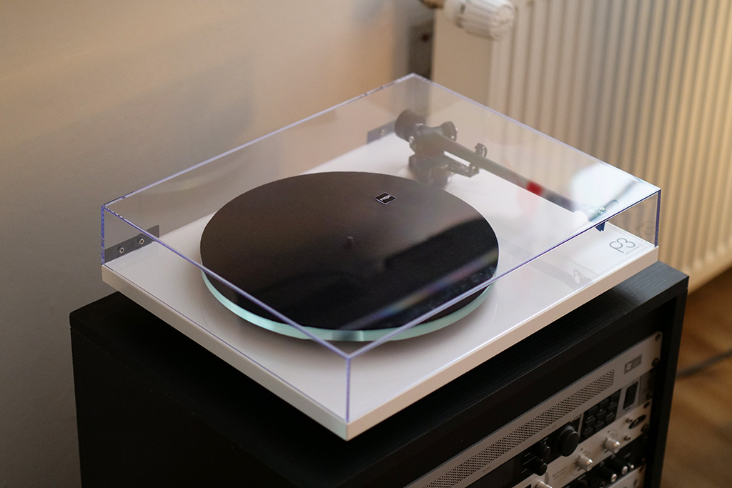La platine Rega P3 avec son couvre-plateau en acrylique. La platine Rega P3 avec son couvre-plateau en acrylique.
