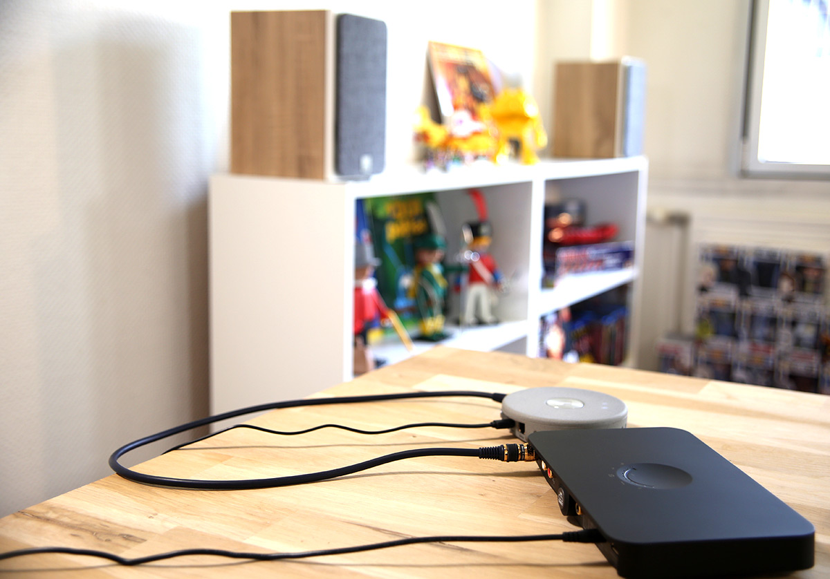 Au premier plan le hub Dali avec un lecteur réseau audio. En second plan les enceintes actives Oberon 1C Le hub Dali avec un le lecteur réseau Audio Pro Link déporté. Les enceintes Oberon 1C sont à quelques mètres en liaison sans fil sur un autre meuble au fond de la pièce